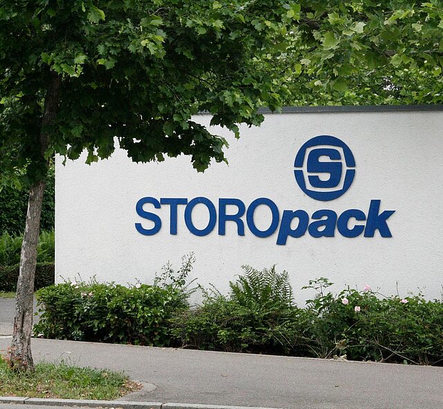 Eine weiße Mauer mit blauem Storopack Logo